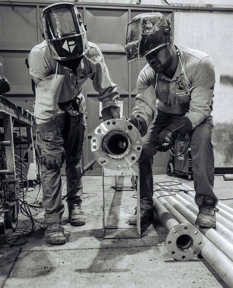 Trabajador soldando estructura metálica en taller